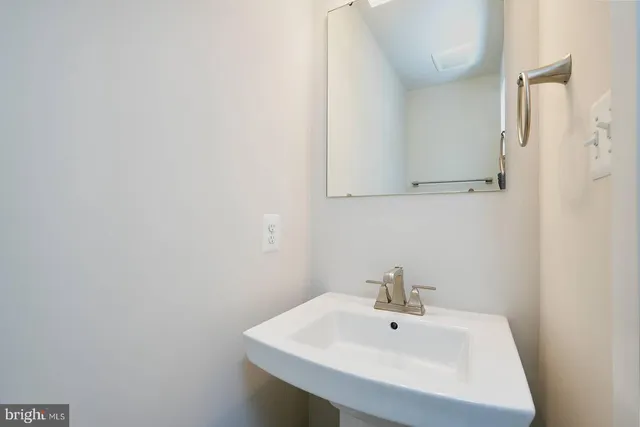 a white kitchen with kitchen island a counter top stainless steel appliances and cabinets