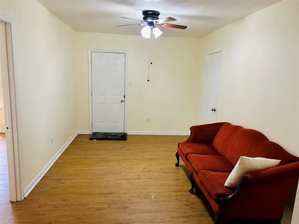 a living room with furniture and a ceiling fan