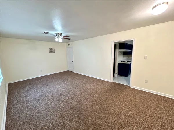 an empty room with fan and entrance