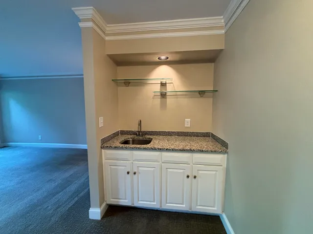 a bathroom with a granite countertop sink and white cabinets