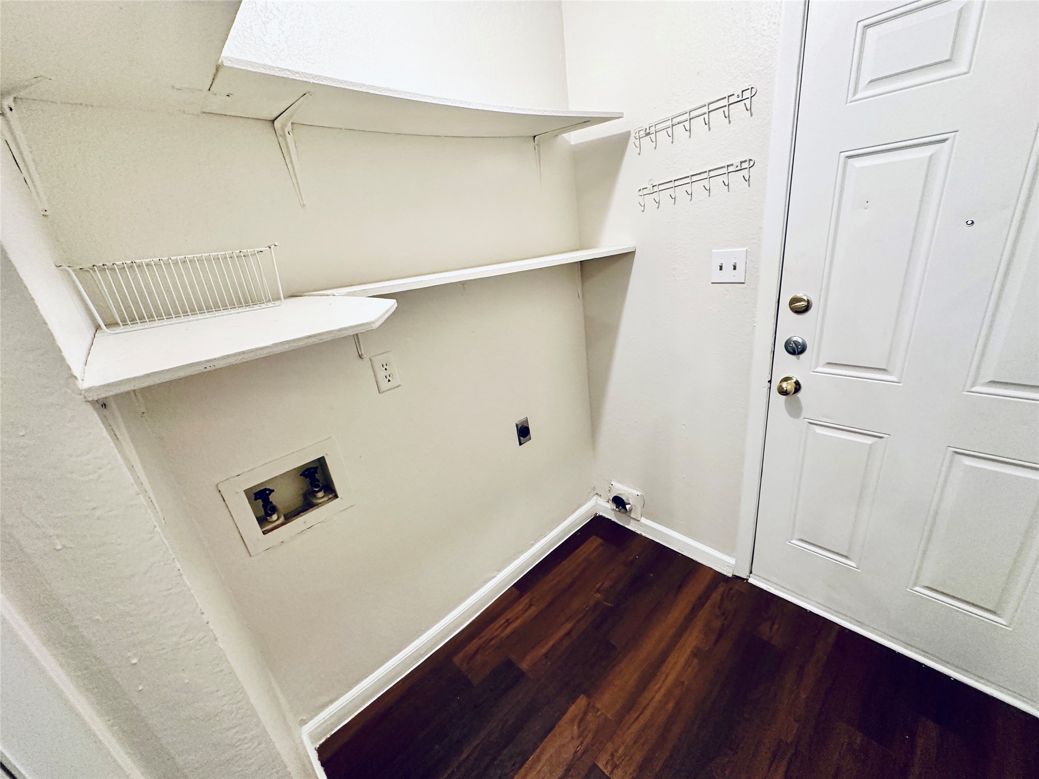 12505 Turtle Rock Road, Unit A Austin, TX 78729 - Photo 8 of 38 Functional laundry nook with built-in shelving, ready for a washer and dryer setup.