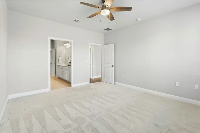 a view of an empty room and chandelier fan
