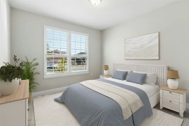 a bedroom with a large bed and a potted plant