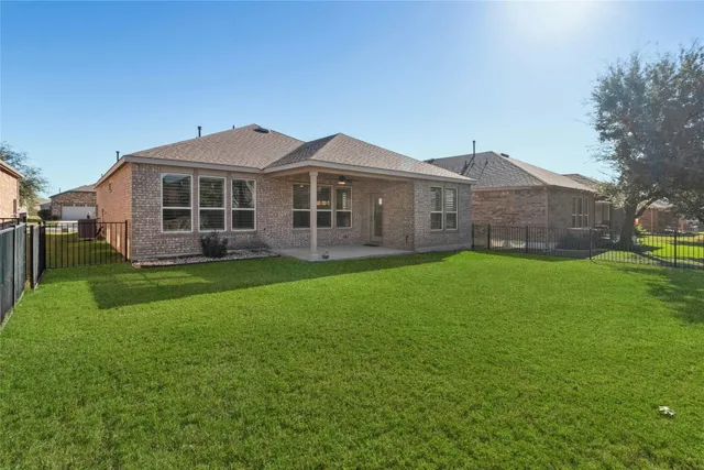 a front view of a house with a garden and trees
