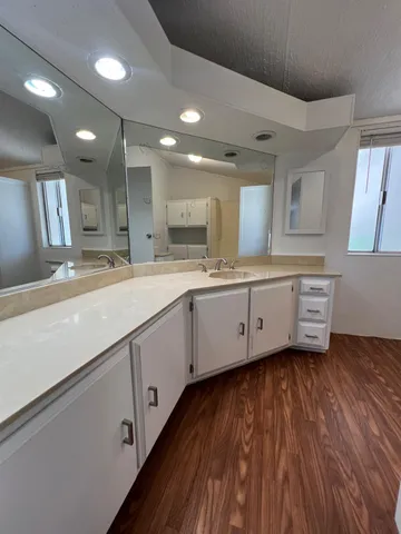 a kitchen with a sink window and a large mirror