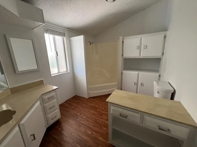 a view of a kitchen with wooden floor and electronic appliances