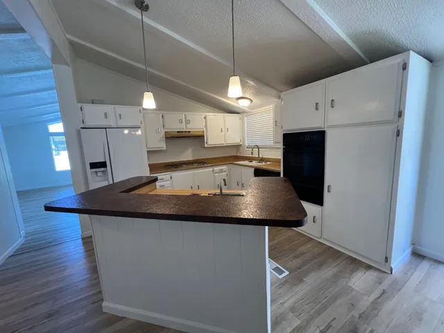 a kitchen with stainless steel appliances granite countertop a sink a refrigerator and a microwave