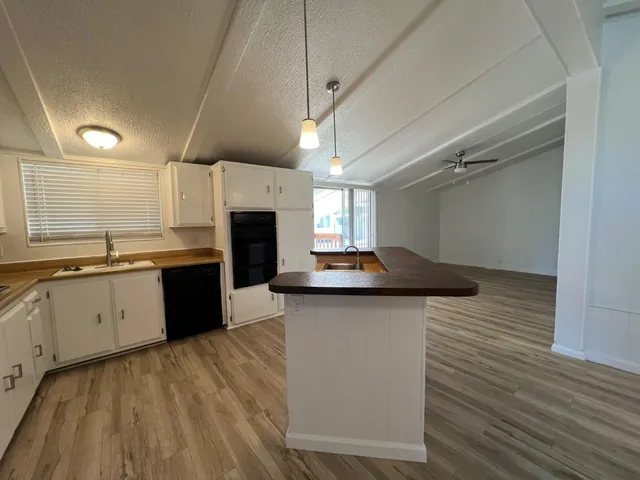 a kitchen with granite countertop a sink cabinets and stainless steel appliances