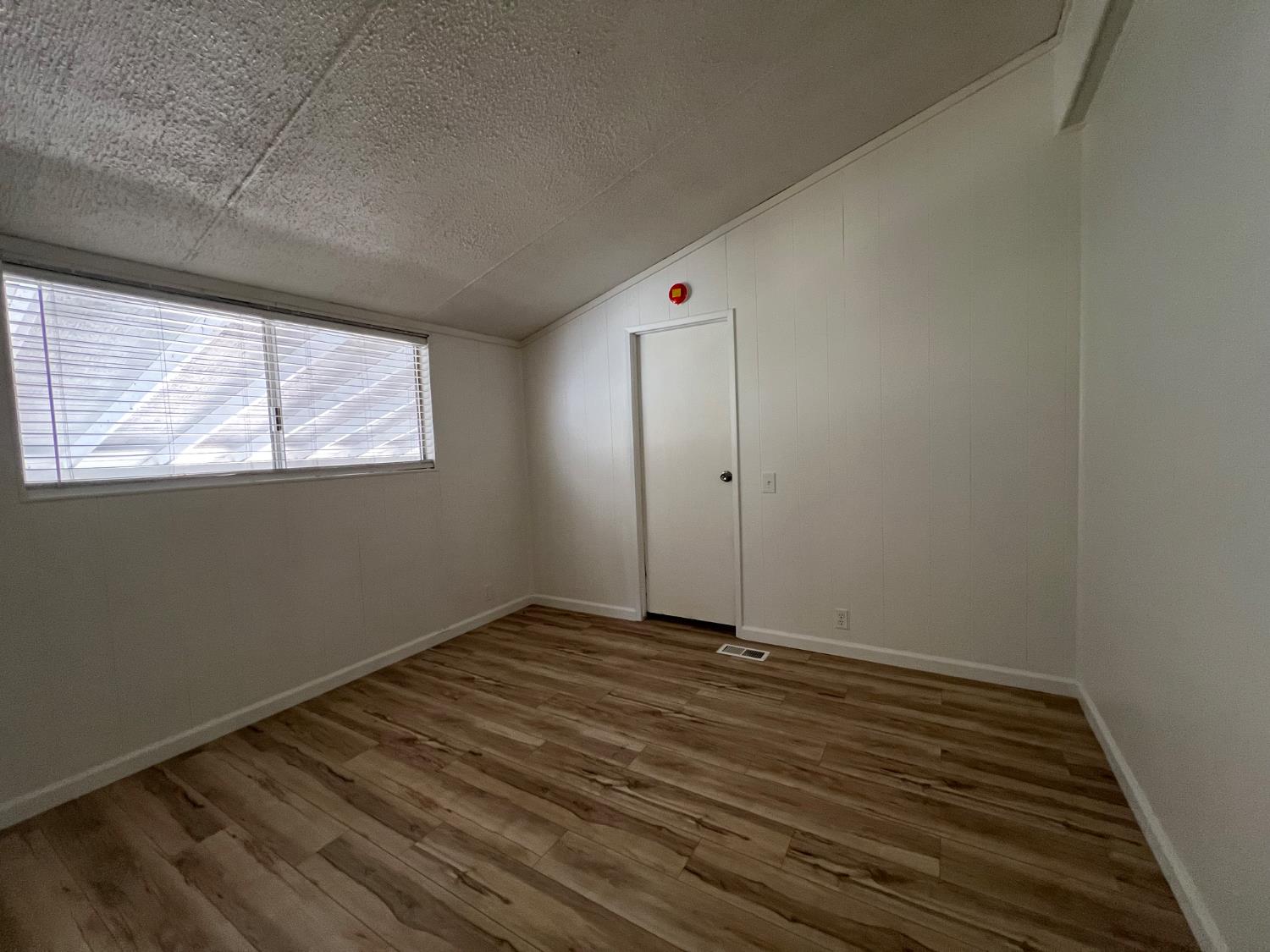 2240 Golden Oak Lane, Unit 134 Merced, CA 95341 - Photo 10 of 29 an empty room with wooden floor and windows