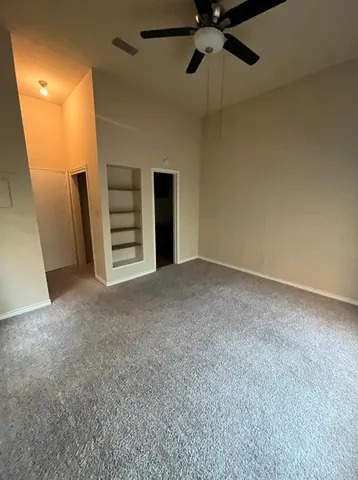 a view of an empty room with a ceiling fan