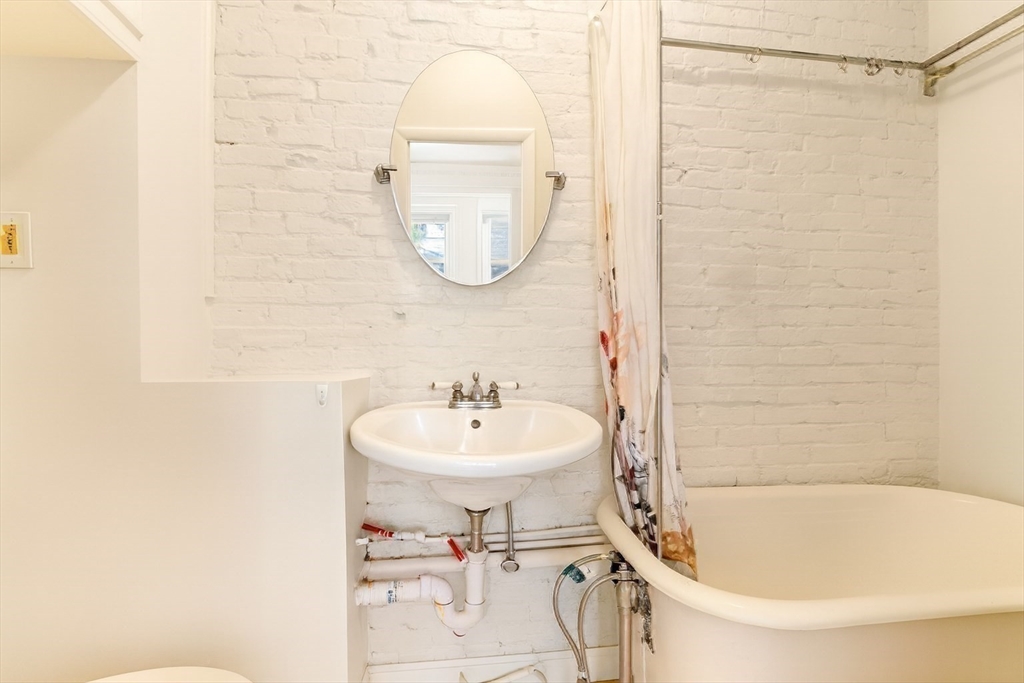 39 Revere Street, Unit 6 Boston, MA 02114 - Photo 21 of 22 a bathroom with a sink a mirror and a shower
