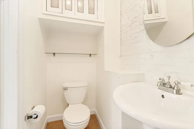 a bathroom with a sink a toilet and a mirror