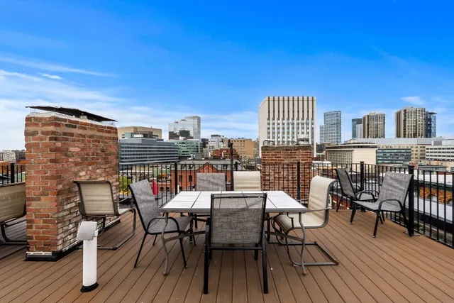 a view of a roof deck with table and chairs