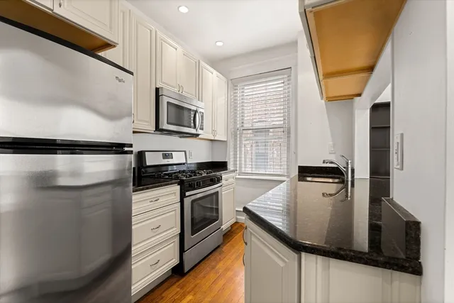 a kitchen with stainless steel appliances granite countertop a stove a sink and a microwave