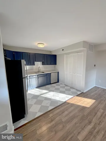 a view of kitchen with refrigerator stove and wooden floor