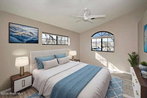 an empty room with wooden floor chandelier and windows
