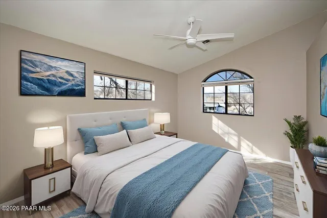 an empty room with wooden floor chandelier and windows