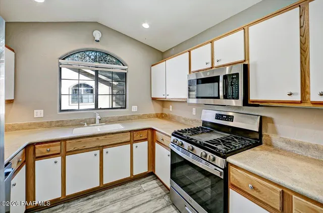 a kitchen with granite countertop a stove top oven microwave and cabinets