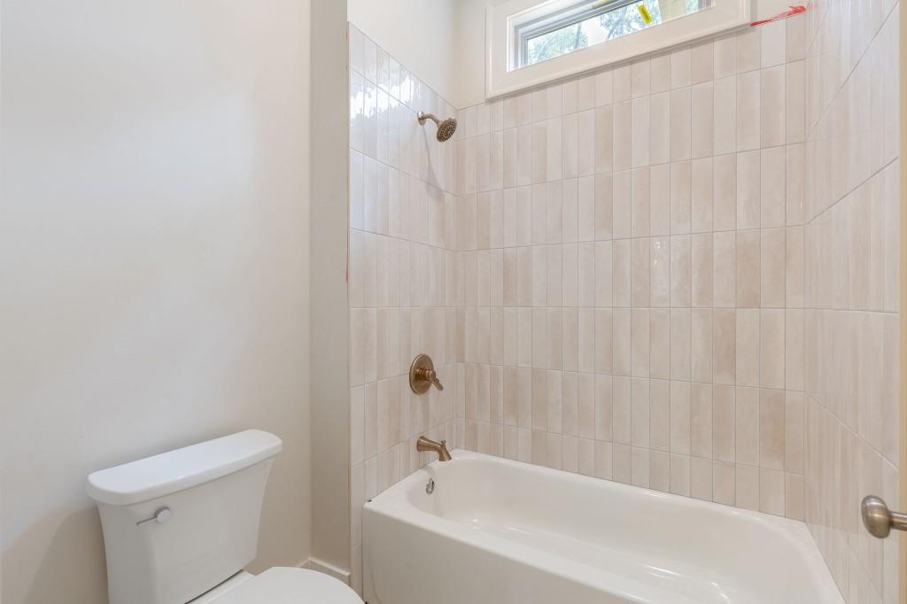 2001 Epperson Road Canton, GA 30115 - Photo 39 of 76 a white bath tub sitting next to a white toilet and a shower curtain