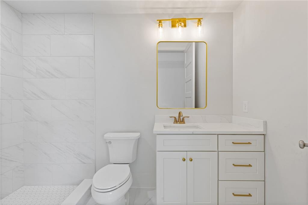 2001 Epperson Road Canton, GA 30115 - Photo 68 of 76 a bathroom with a toilet sink vanity and mirror