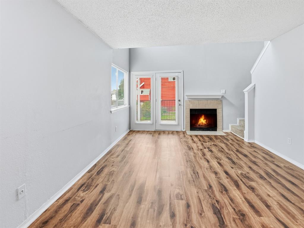 9835 Walnut Street, Unit 208 Dallas, TX 75243 - Photo 2 of 13 a view of an empty room with wooden floor fireplace and a window