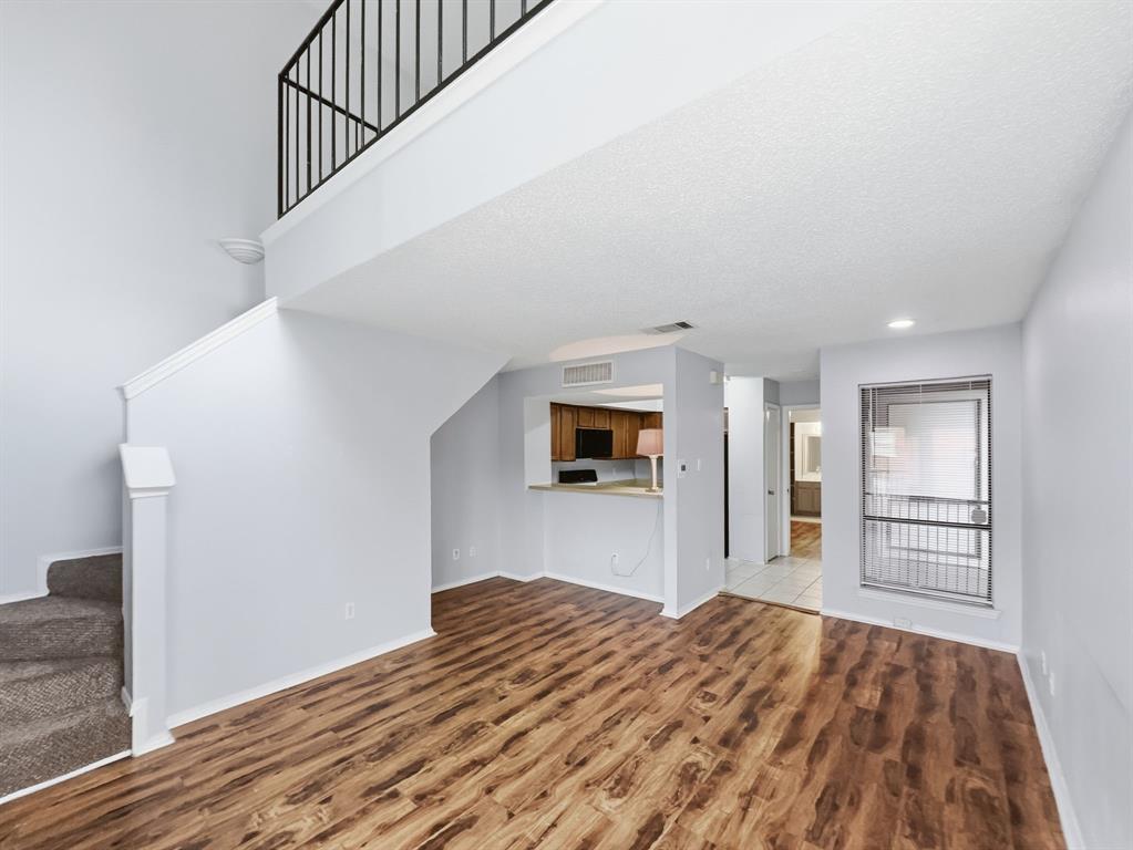 9835 Walnut Street, Unit 208 Dallas, TX 75243 - Photo 3 of 13 a view of a bedroom with wooden floor and staircase