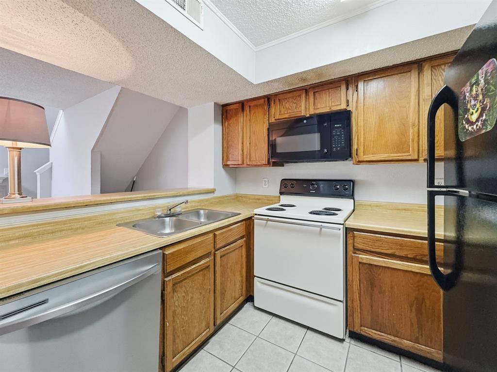 9835 Walnut Street, Unit 208 Dallas, TX 75243 - Photo 7 of 13 a kitchen with a stove microwave and sink