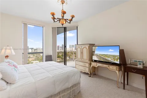 a bedroom with a bed and a large window