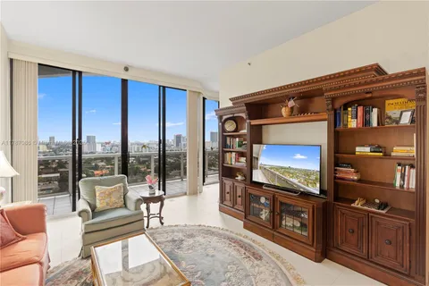 a living room with furniture and a floor to ceiling window