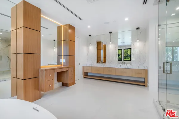 a bathroom with a tub sink shower and mirror