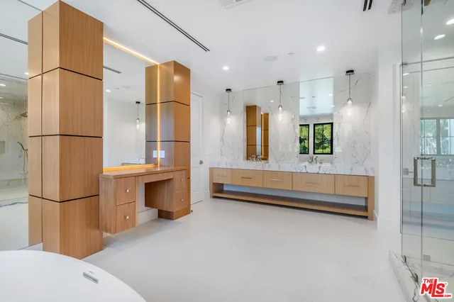 a bathroom with a tub sink shower and mirror