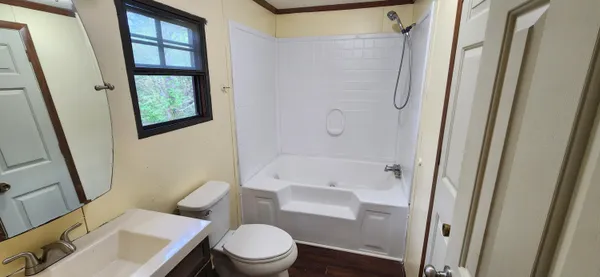 a white toilet sitting next to a bathroom sink and tub