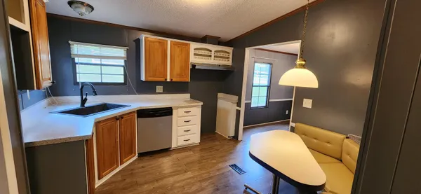 a kitchen with a sink cabinets and wooden floor