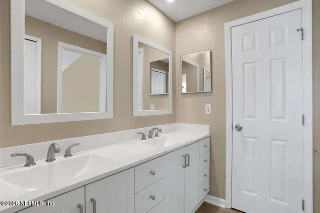 a bathroom with 2 sink and a mirror