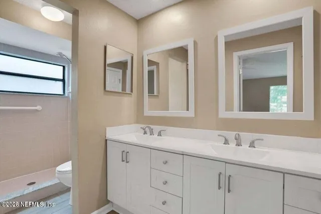 a bathroom with a toilet a sink a and mirror