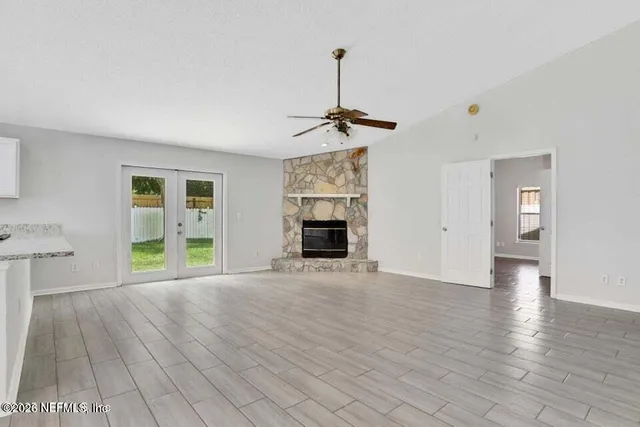 a view of empty room with wooden floor and fireplace