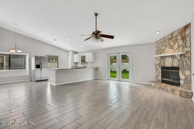 a view of empty room with wooden floor and a fireplace