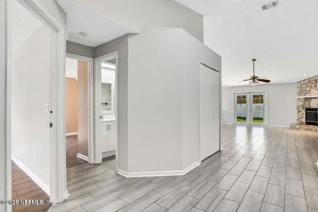 a view of a hallway with wooden floor and a living room