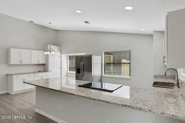 a kitchen with granite countertop a sink and a stove top oven