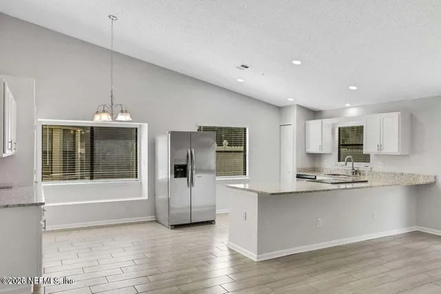 a kitchen with stainless steel appliances a refrigerator sink and microwave