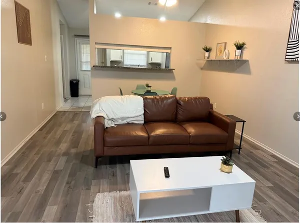 a living room with furniture and a wooden floor