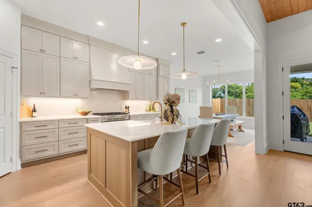 a kitchen with stainless steel appliances kitchen island granite countertop a sink stove and refrigerator