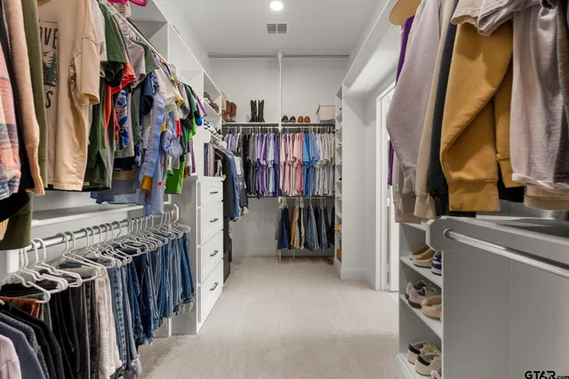 a view of walk in closet with clothes