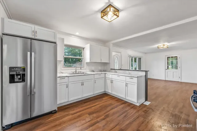 a kitchen with a refrigerator and a white cabinets