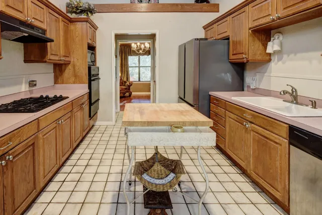 a kitchen with a sink a refrigerator and cabinets