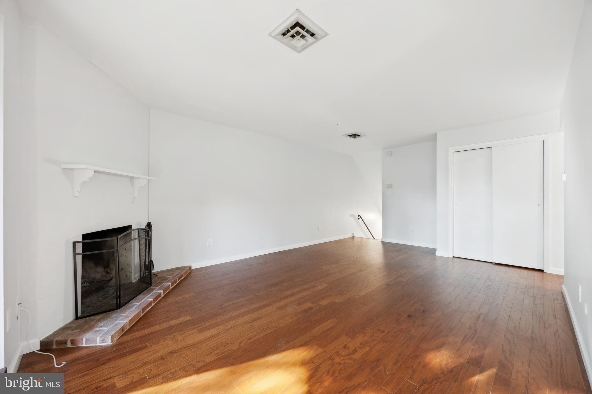 411 Conestoga Road, Unit 27 Devon, PA 19333 - Photo 6 of 15 a view of empty room with wooden floor and fireplace