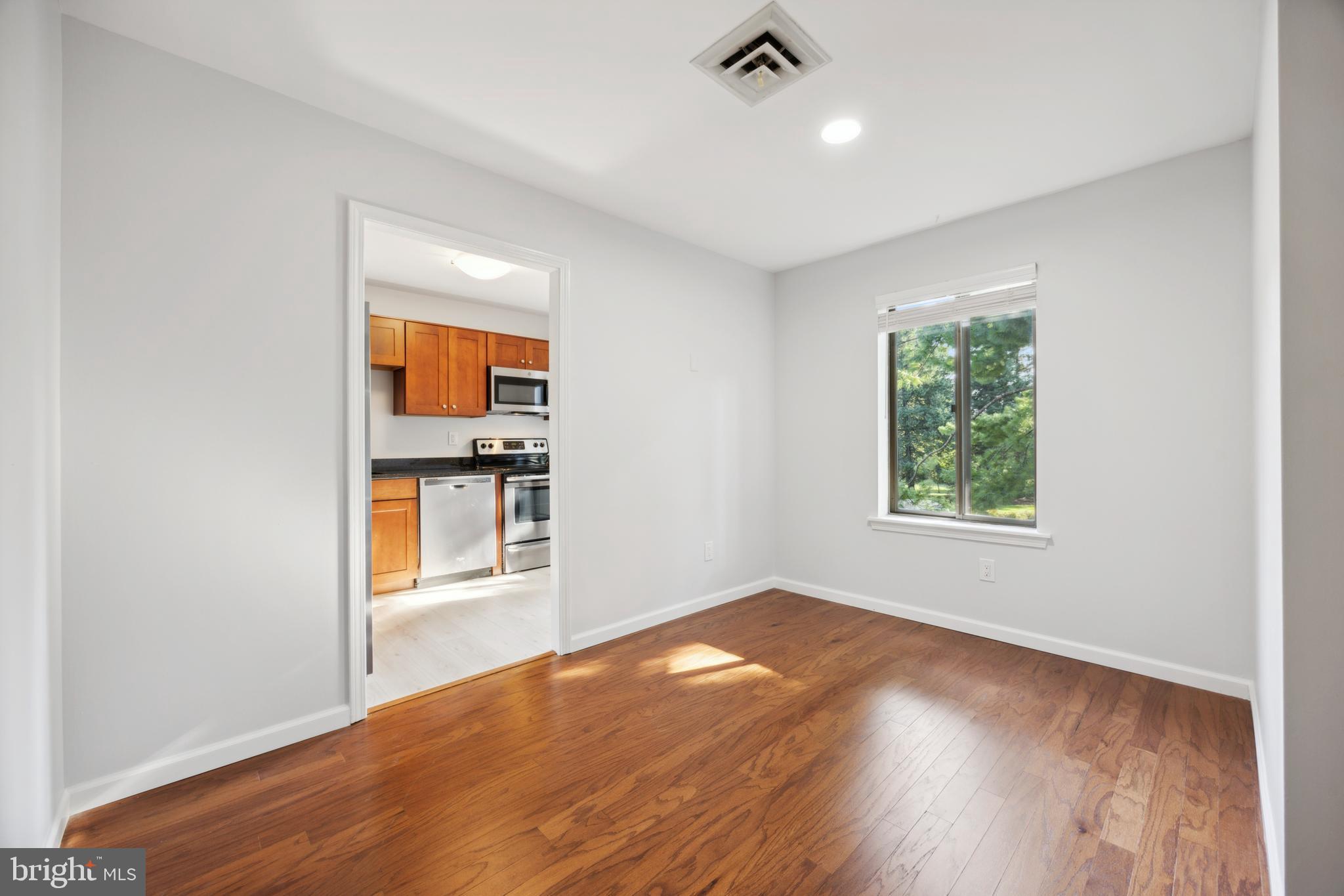 411 Conestoga Road, Unit 27 Devon, PA 19333 - Photo 7 of 15 an empty room with wooden floor and windows