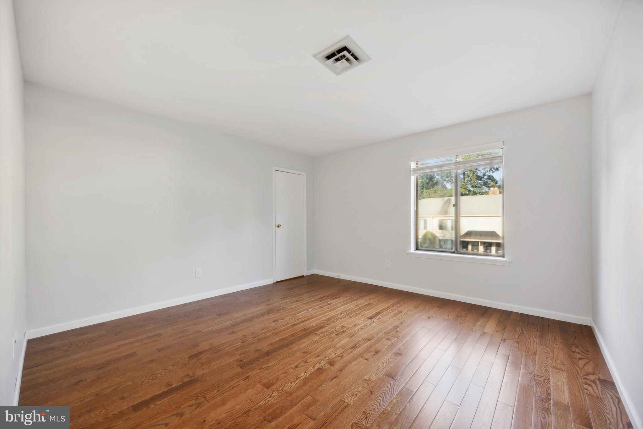 411 Conestoga Road, Unit 27 Devon, PA 19333 - Photo 8 of 15 an empty room with wooden floor and windows
