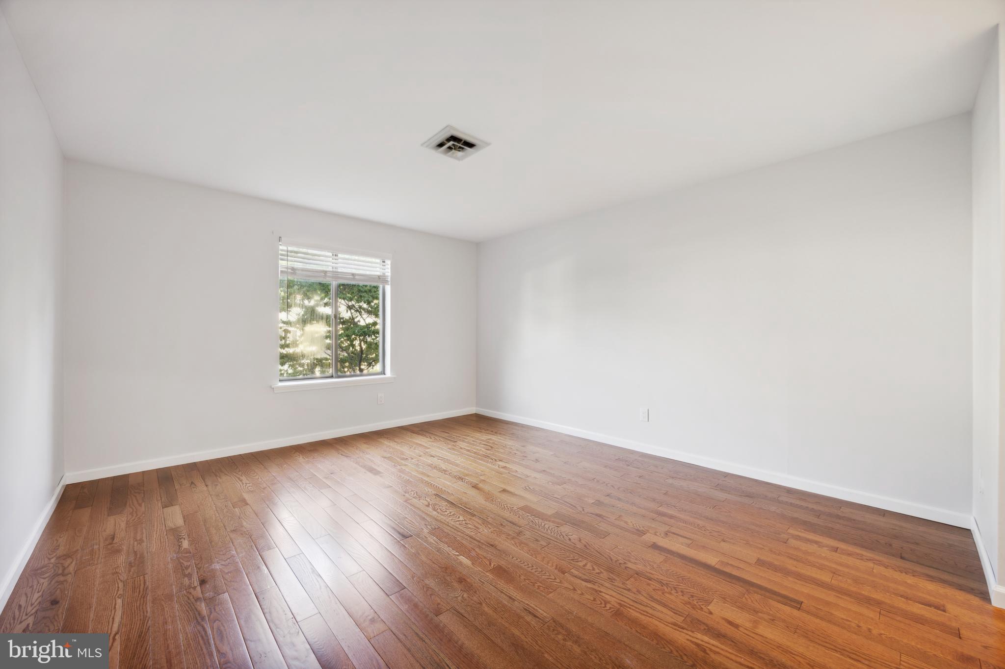 411 Conestoga Road, Unit 27 Devon, PA 19333 - Photo 9 of 15 an empty room with wooden floor and windows