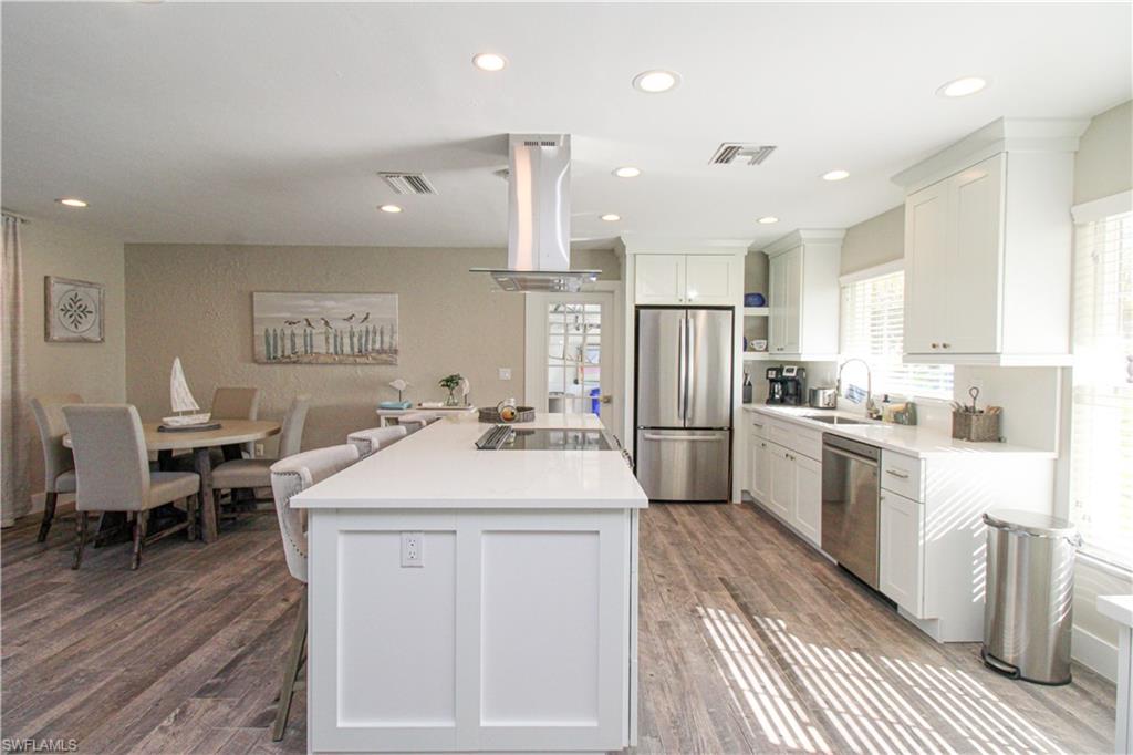 1353 Pelican Avenue Naples, FL 34102 - Photo 19 of 41 a kitchen with stainless steel appliances kitchen island granite countertop a sink refrigerator and cabinets